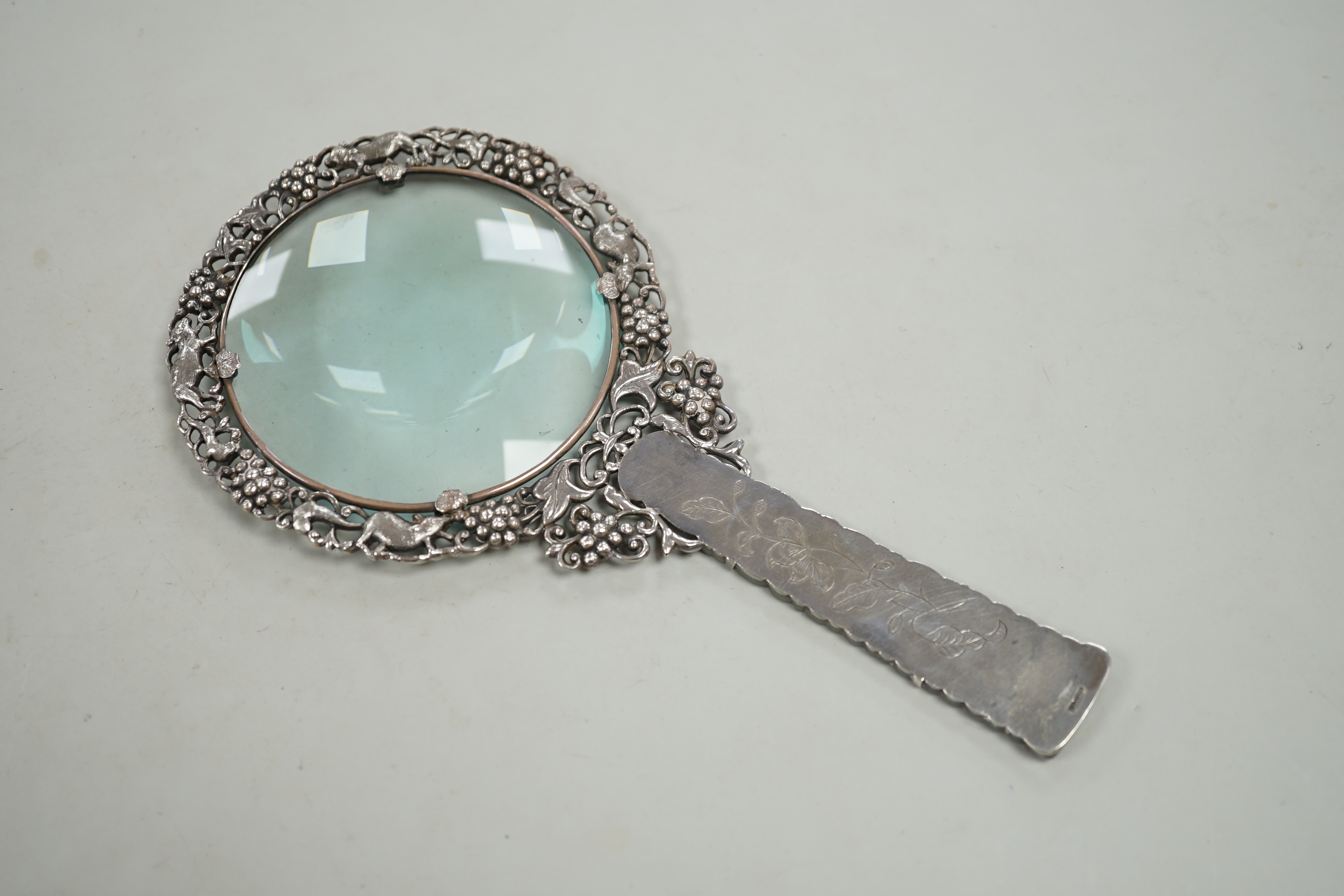 A Chinese white metal and pale celadon jade handled magnifying glass, early 20th century, stamped ‘SILVER’, 19cm long